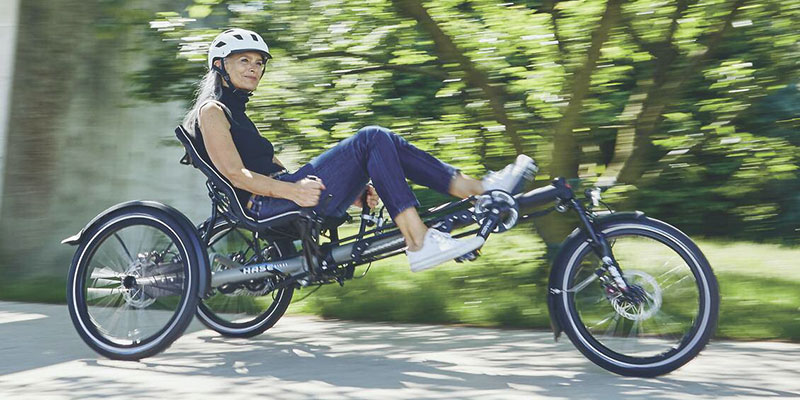 Photo of a woman riding a Hase Bikes Kettwiesel Evo Steps recumbent trike