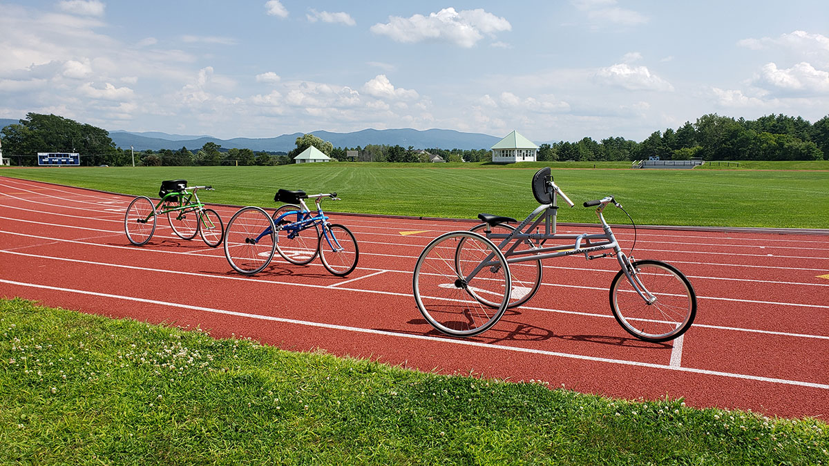 Photo of small, medium and large RAD RaceRunner running trikes on a running track.