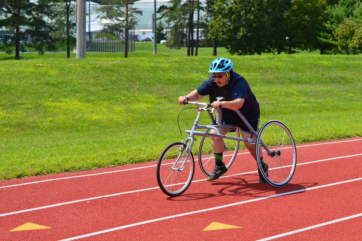 Cari W., a Vermont Special Olympian, tests out a RAD RaceRunner™ running frame at a local track.