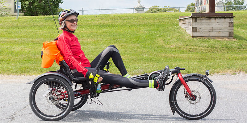 Smiling woman riding a Hase Kettwiesel delta recumbent trike