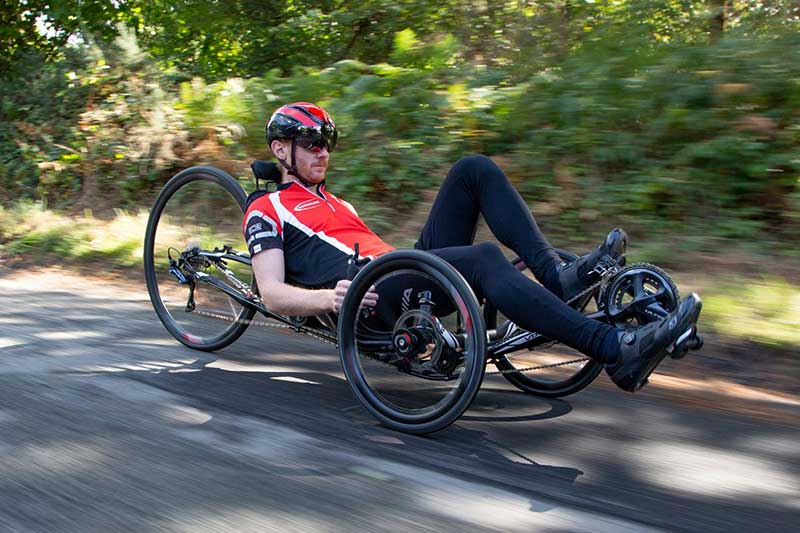 Man riding an ICE VTX racing recumbent trike on a country road