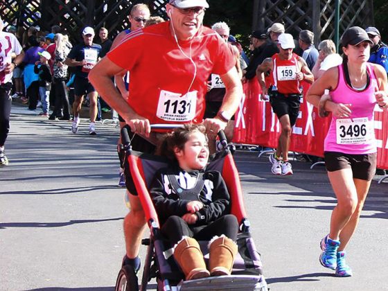 Man in a race pushing a child in an X-Jogger