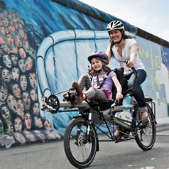 Smiling woman and girl on a Hase Pino tandem 