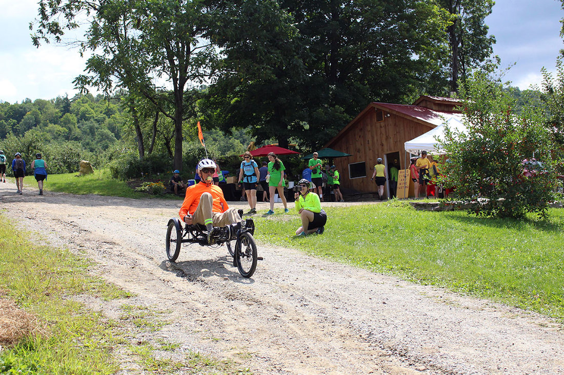 Man riding a recumbent trike stopping at a farm on the Tour de Farms in Vermont